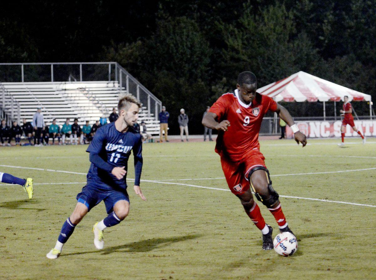 Senior forward Ade Taiwo keeps the ball from Seahawk junior defender Huntley Munn Tuesday in Dail Soccer Field. Taiwo scored the winning goal of the game with under five minutes to go, bringing NC State a 2-1 win against UNC-Wilmington.