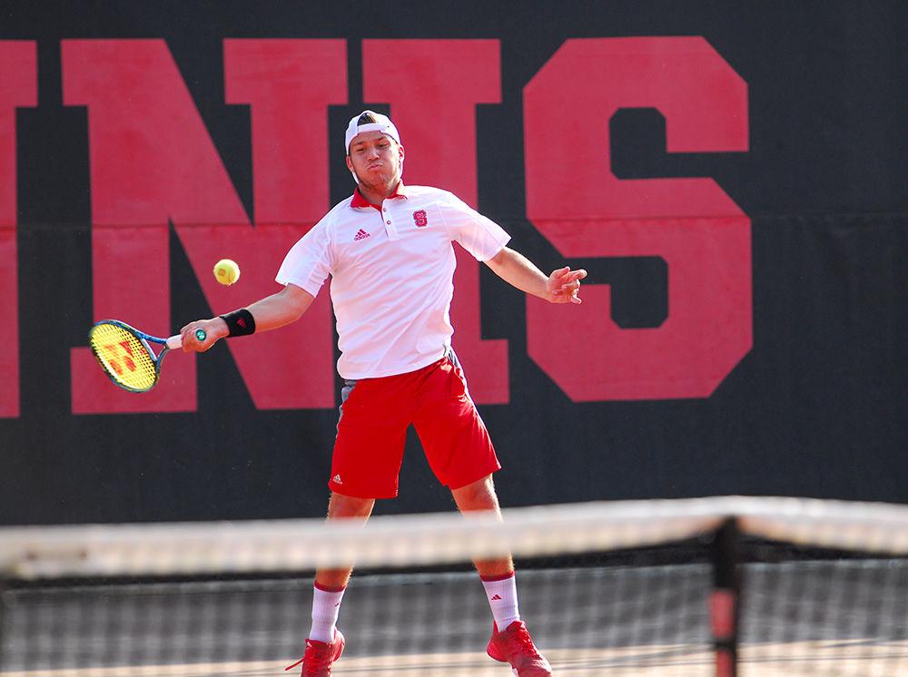 Freshman Alexis Galarneau returns the ball to opponent Collin Altamirano at the men&#8217;s tennis match against Virginia in J.W. Isenhour Tennis Center on March 24. The Wolfpack lost all matches to Virginia with a final score of 0-7. However, Galarneau alongside senior Nick Horton tied their opponents from Virginia in a doubles match.