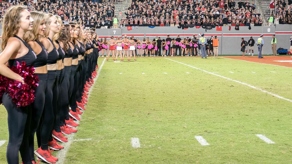 Chearleaders stand at attention for the Alma Mater at the end of the 39-25 win over Louisville in Carter-Finley Stadium on Thursday, October 5
