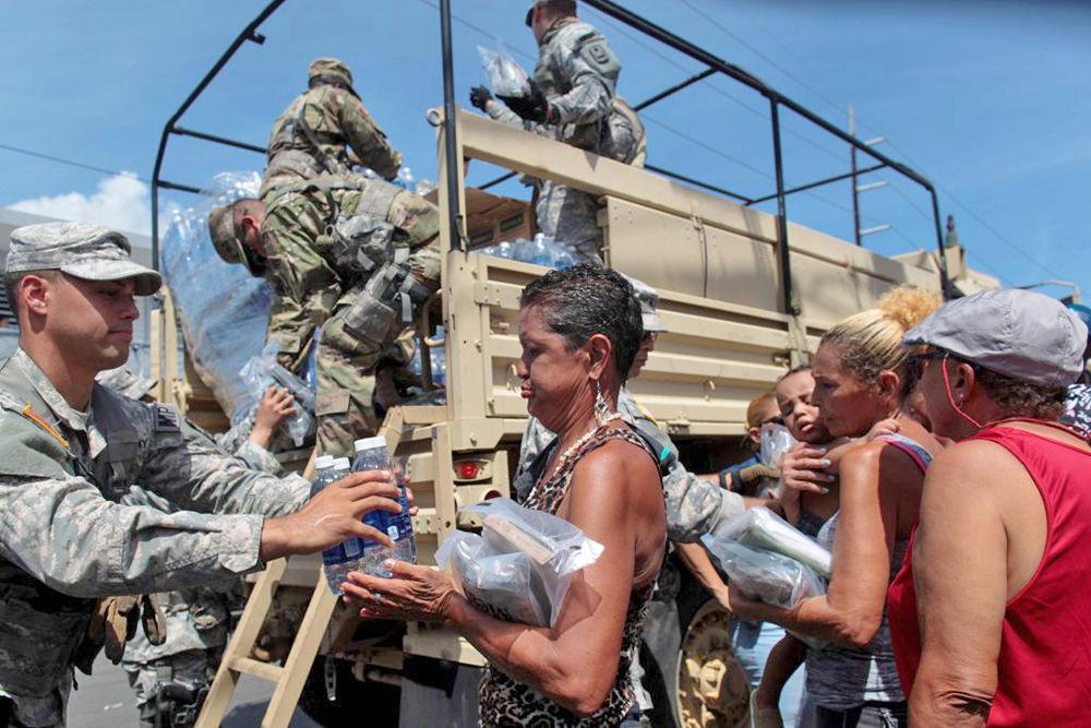 Soldiers of Puerto Rico&#8217;s national guard distribute relief items to people, after the area was hit by Hurricane Maria in San Juan, Puerto Rico.