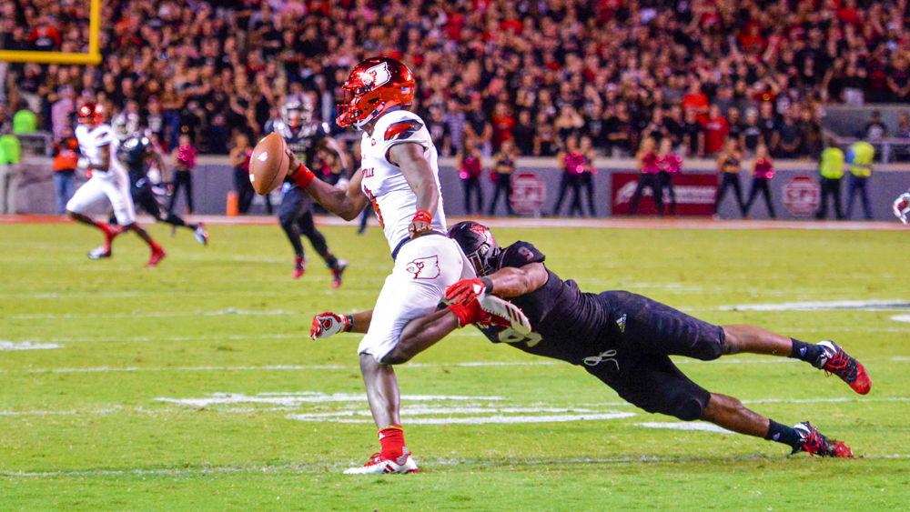 Senior defensive end Bradley Chubb dives in an attempt to bring down the Louisville quarterback Lamar Jackson during the game against the Cardinals. The NC State defense generated 4 sacks and 5 quarterback hurries. The Wolfpack won 39-25 in Carter Finley Stadium on Thursday, Oct. 5.