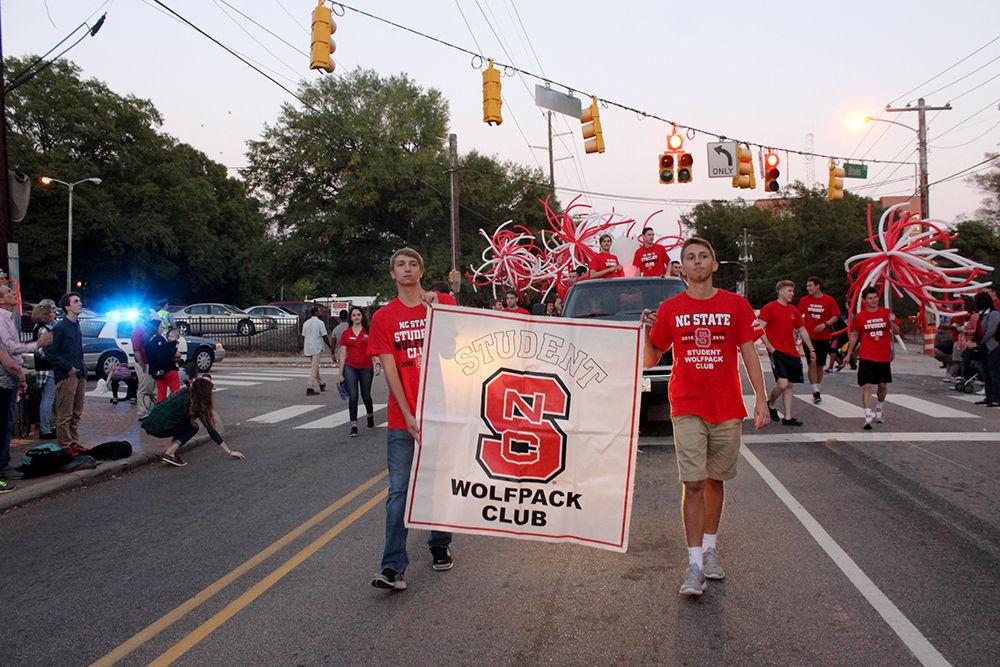 The Student Wolfpack Club march with their float in the homecoming parade on Oct. 28. The annual parade ran down Hillsborough St. and featured floats from different student organizations.