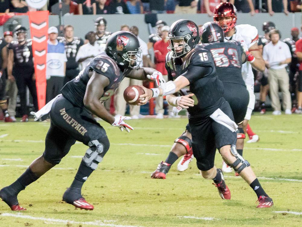 Redshirt junior Ryan Finley hand the ball off to junior running back Reggie Gallaspy in the 39-25 win over Louisville in Carter-Finley Stadium on Thursday, October 5.