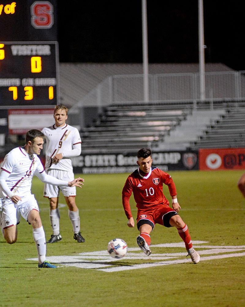 Freshman forward David Loera passes the ball off to a teammate after slipping between defenders during the NC State vs. Boston College men's soccer game at Dail Soccer Stadium on Friday, Oct. 27. The Wolfpack drew with the Golden Eagles after overtime with a score of 0-0.