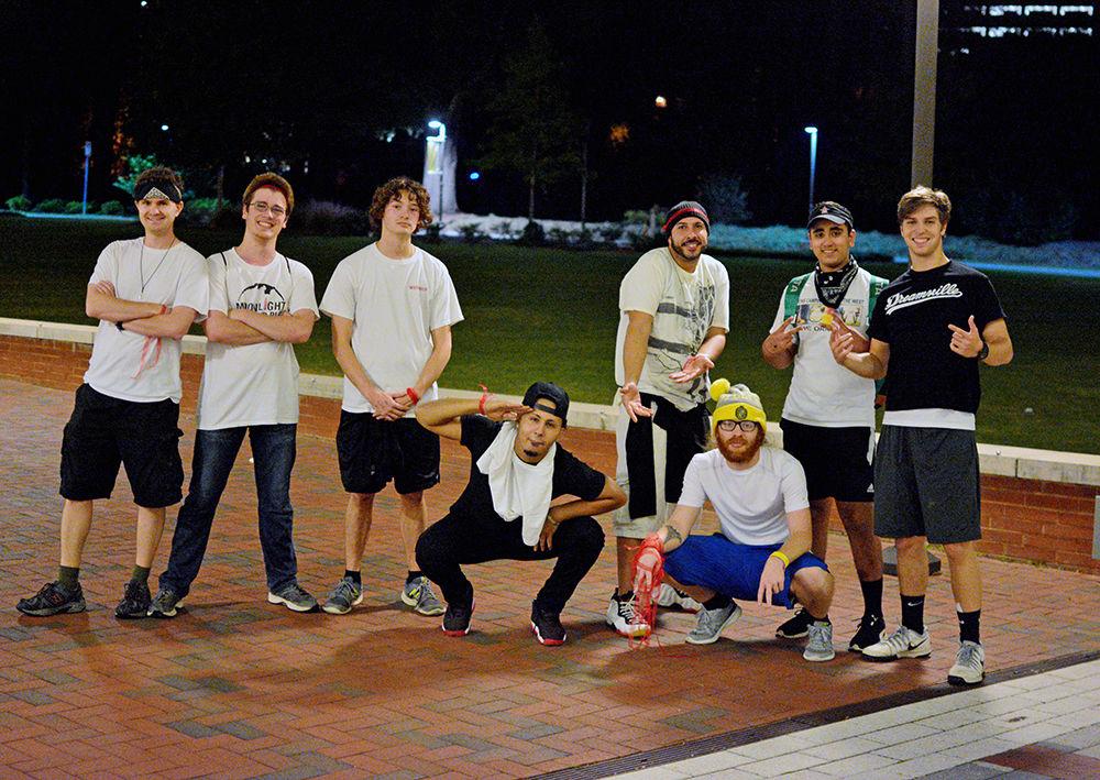 Participants of Survive Raleigh pose for a group picture on Oct. 28. The game involves zombies wearing white shirts trying to tag humans wearing black shirts. To win, a human must make it to all four checkpoints without getting tagged by a zombie.