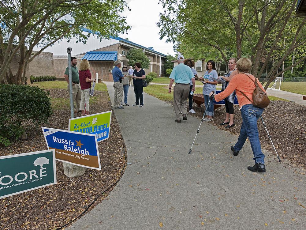 Voters talking to campaign workers on their way into the polls at Lead Mine Elementary School in North Raleigh, on Election Day, Tuesday.