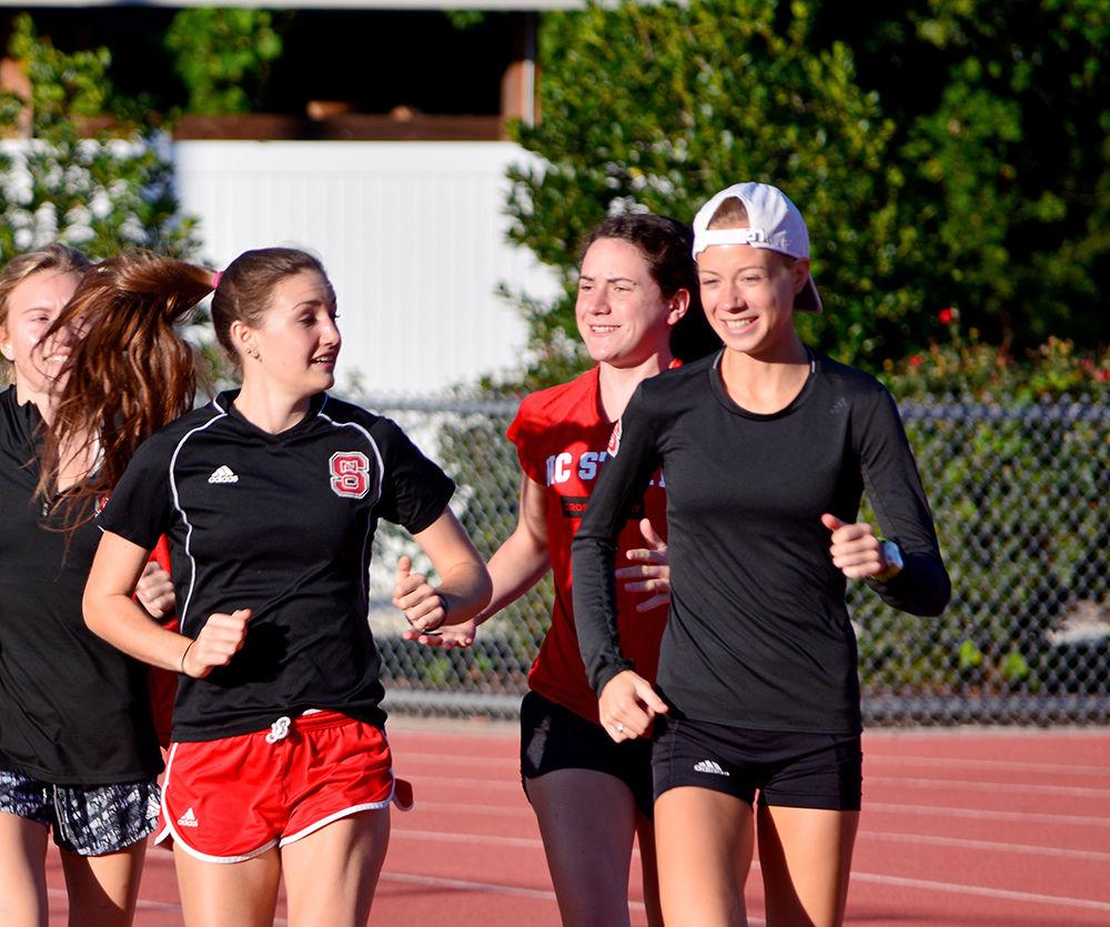 Red shirt junior Rachel Koon (right) talks to teammates while warming up at practice on Friday, Sept. 8 at Paul Derr Track. The women's cross country team has their first meet of the season on Sept. 15.