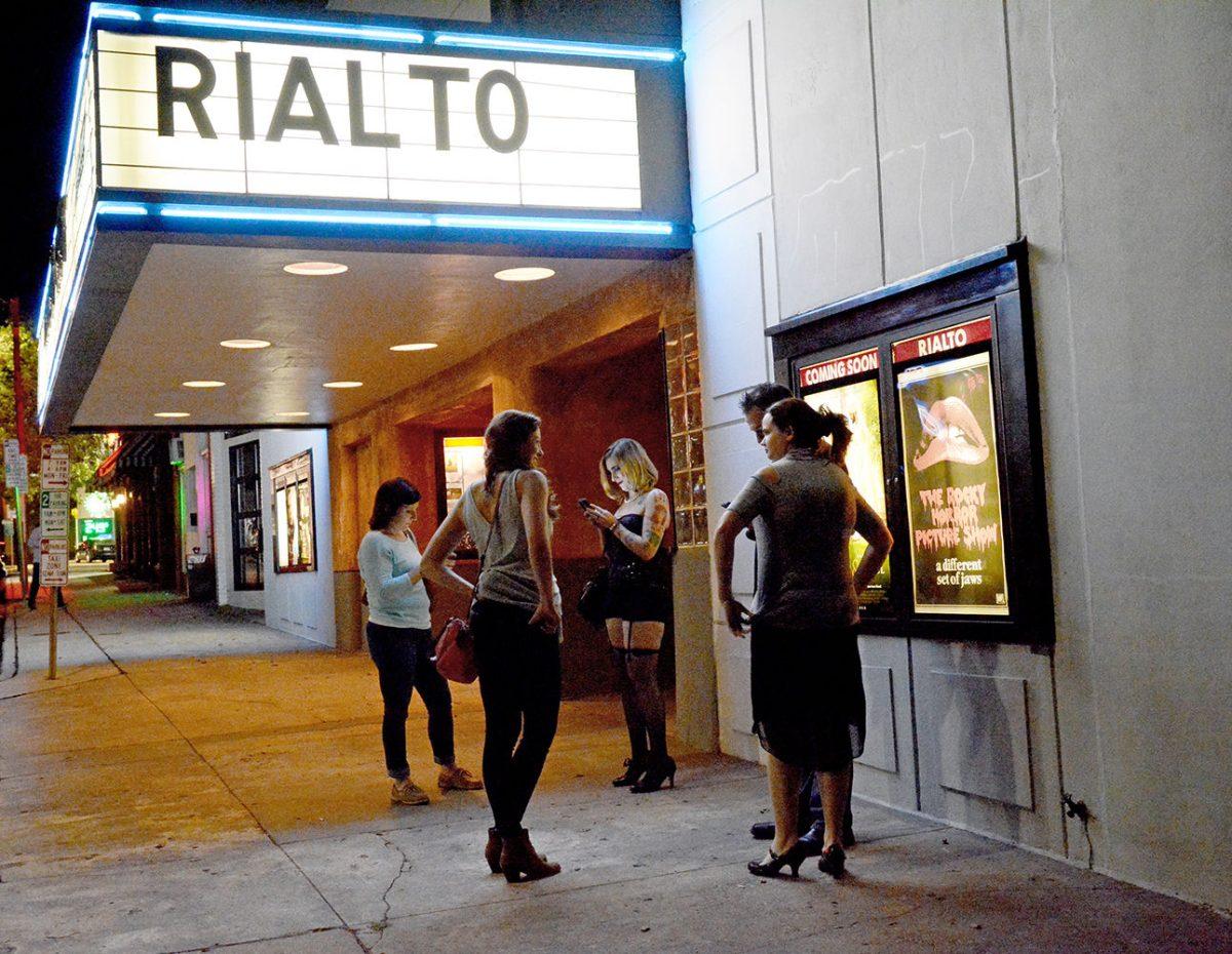 A group of people wait outside of the Rialto for the Rocky Horror Picture Show on Friday, Oct. 30. There are traditions associated with the showing and some attendees dress up for the occasion.