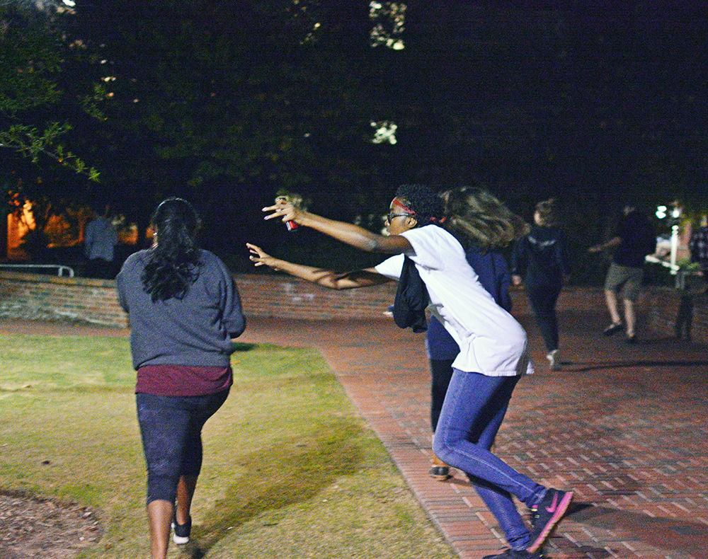 Zombies wearing white shirts try to tag humans wearing black shirts during Survive Raleigh on Oct. 28. To win, a human must make it to all four checkpoints without getting tagged by a zombie.