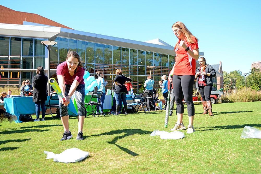 Marissa Petri, a fourth-year studying biology, smashes a scale while her friend Isabelle Babson, a junior studying psychology, looks on during the annual Southern Smash event at Stafford Commons Tuesday. According to McCall Dempsey, the founder of Southern Smash, the event was started 5 years ago and occurs on campuses across the country to promote positive body image and awareness of eating disorders.