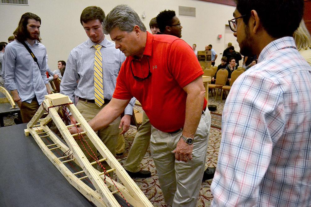 Greg Holton, a resident of New Bern, inspects the collapsible bridge built by team Truss-worthy during First Year Engineering Design Day on Tuesday, November 21, 2017 in the McKimmon Center. Truss-worth ended up receiving the runner up place during the morning session of FEDD. Much of their project materials were donated, costing the team only $12 out of pocket to build the bridge.