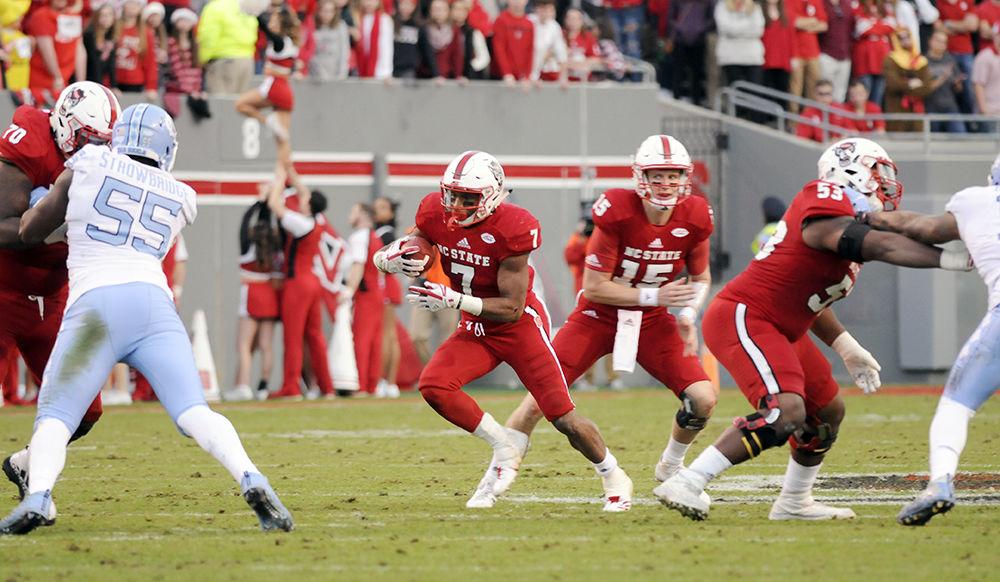 Junior runningback Nyheim Hines runs past the UNC-CH defense after receiving the ball from from redshirt junior quarterback Ryan Finley against UNC-Chapel Hill in Carter-Finley Stadium on Saturday. The Wolfpack won 21-33 claiming their eighth win of the season.