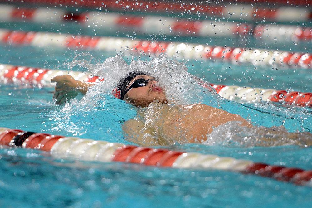 Senior Hennessey Stuart reaches forward for an arm stroke during the backstroke at the meet against Texas. The Wolfpack men's team won 176-116 over the Longhorns in Willis R. Casey Aquatic Center on Friday.&#160;