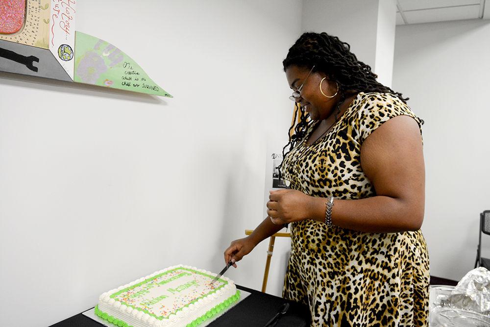Editor-in-Chief of Nubian Message Anahzsa Jones cuts the cake for the 25th anniversary of the publication at the African American Cultural Center Thursday, Nov. 30.