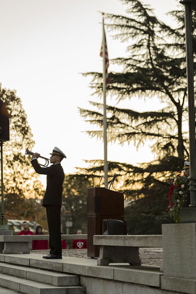 A Naval ROTC Cadet Bugler plays Taps honoring the fallen Wolfpack Alumni at the base of the Memorial Belltower on Veterans Day, Friday, November 10. The Memorial Belltower was originally built to honor the 34 Alumni that died in WWI and now serves to honor all students that serve past, present, and future.