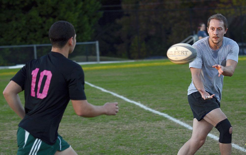 Mende Carlton, a second-year in exploratory studies, passes to Matthew Frink, a third-year studying paper science, during Club Rugby practice at Method Road Fields on Oct. 31.