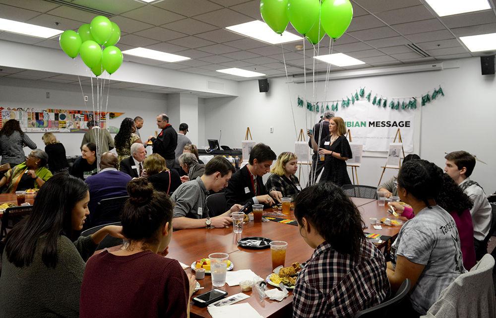 Attendees enjoy food catered by Dame's Chicken &amp; Waffles at the Nubian Message's 25th anniversary celebration at the African American Cultural Center Thursday, Nov. 30.