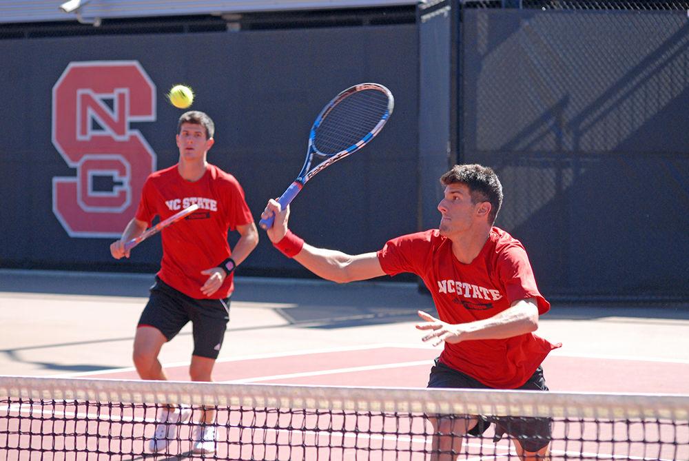 Junior Ivan Saveljic runs to hit a tennis ball in a practice doubles match with his brother Igor Saveljic at J.W. Isenhour Tennis Center on Oct. 3.