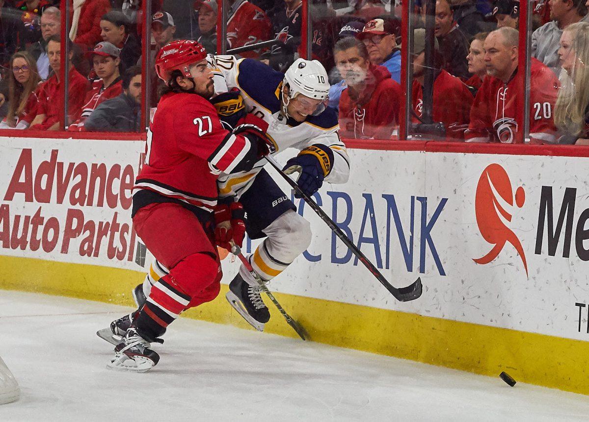 Assistant captain Justin Faulk checks Buffalo center Jacob Josefson into the boards in the second period Saturday, Dec. 23 at PNC Arena for a 4-2 Hurricanes win. Fualk recorded two goals, seven shots on goal and two hits.