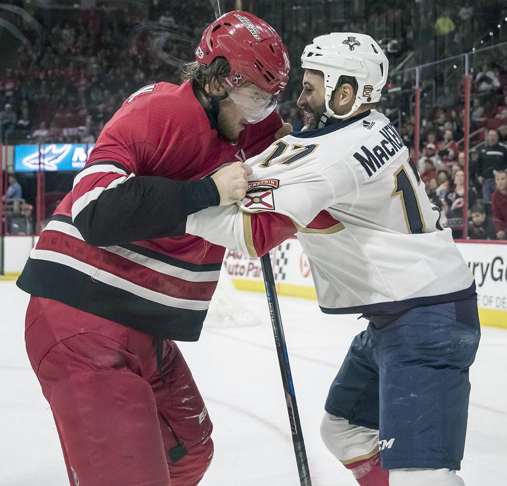 Hurricanes defenseman Noah Hanifin grapples with Florida Panthers captain Derek MacKenzie during the second period of the game in PNC Arena on Saturday. Hanifin went on to score the game winning goal in overtime with two seconds on the clock. The Hurricanes beat Florida 3-2.