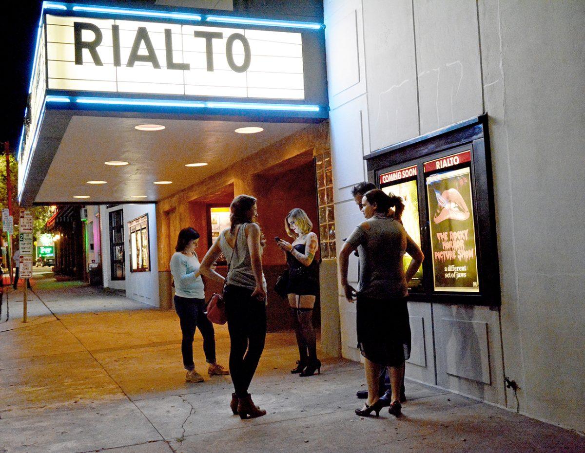 A group of people wait outside of the Rialto for the Rocky Horror Picture Show on Friday, Oct. 30. There are traditions associated with the showing and some attendees dress up for the occasion.