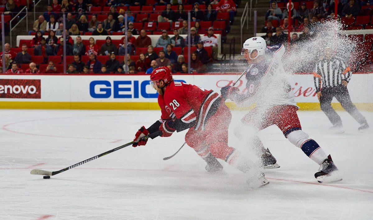 Hurricanes center Elias Lindholm pivots to keep possession of the puck, kicking up snow on Columbus defeseman Zach Werenski at PNC Arena on Saturday. Lindholm won 8 face-offs, registered three hits and blocked one shot against the Blue Jackets. The Canes won 2-1.