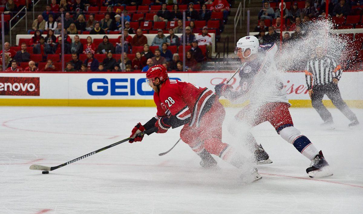 Hurricanes center Elias Lindholm pivots to keep possession of the puck, kicking up snow on Columbus defeseman Zach Werenski at PNC Arena on Saturday. Lindholm won 8 face-offs, registered three hits and blocked one shot against the Blue Jackets. The Canes won 2-1.