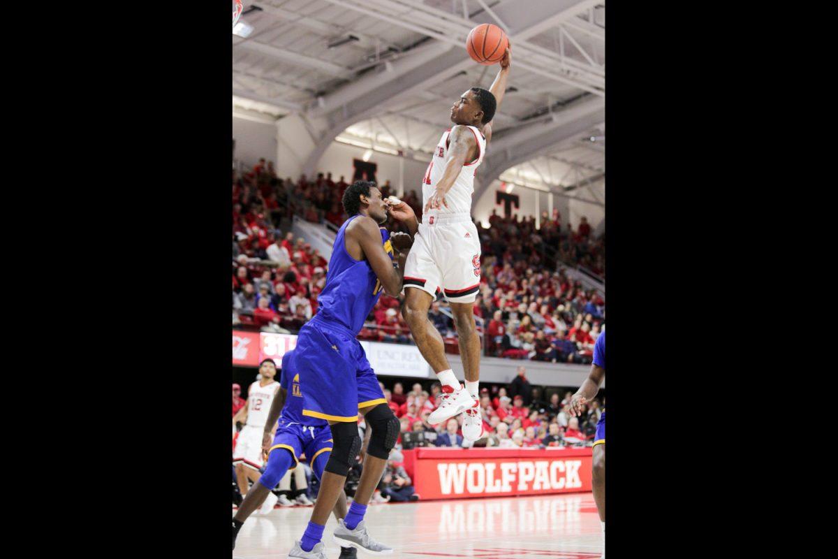Sophomore guard Markell Johnson goes up over UKMC's 7-foot-2 center Mo Ahmed for a huge dunk in the first half. Johnson had a big game with 17 points, three assists and four rebounds in the 88-69 victory over UKMC in Reynolds Coliseum on Saturday Dec. 9.