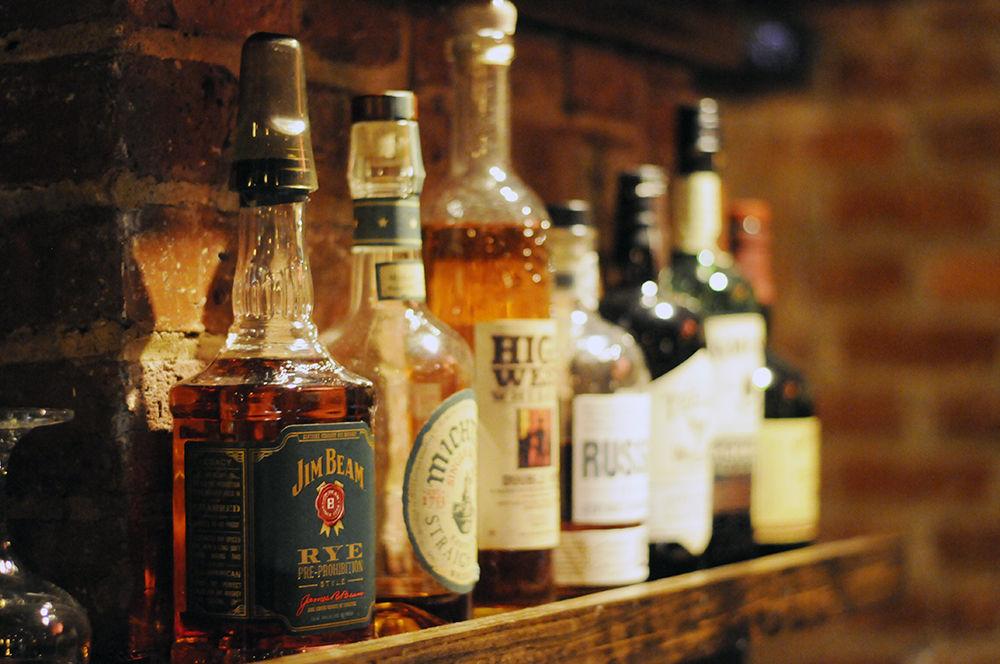 An assortment of alcohol line a portion of the bar at Watts &amp; Ward, a craft cocktail speakeasy located in downtown Raleigh, on Wednesday. The bar offers "bar bites" including caprese skewers and a house made charcuterie.
