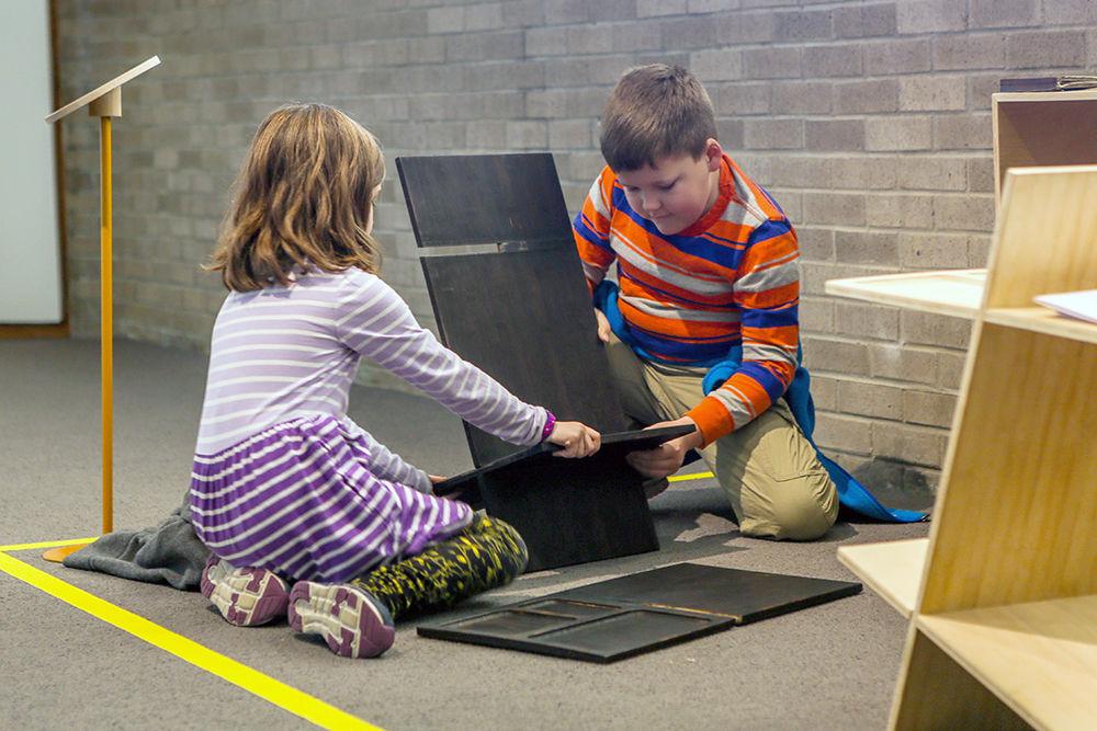 Nine-year-old Hayden Kluttz and his seven-year-old sister Lexie Kluttz interact with the nomadic side table on Sunday in the North Carolina Museum of Art. The table was designed by Jason Swieckowski, a senior studying art and design. The ideal space exhibit, curated by the NC State College of Design, invites interaction with its pieces and runs through Jan. 25.