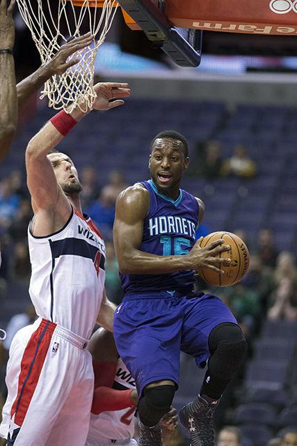 Kemba Walker of the Charlotte Hornets drives against Marcin Gortat of the Washington Wizards during a preseason game at the Verizon Center on Oct. 17, 2014 in Washington, D.C.