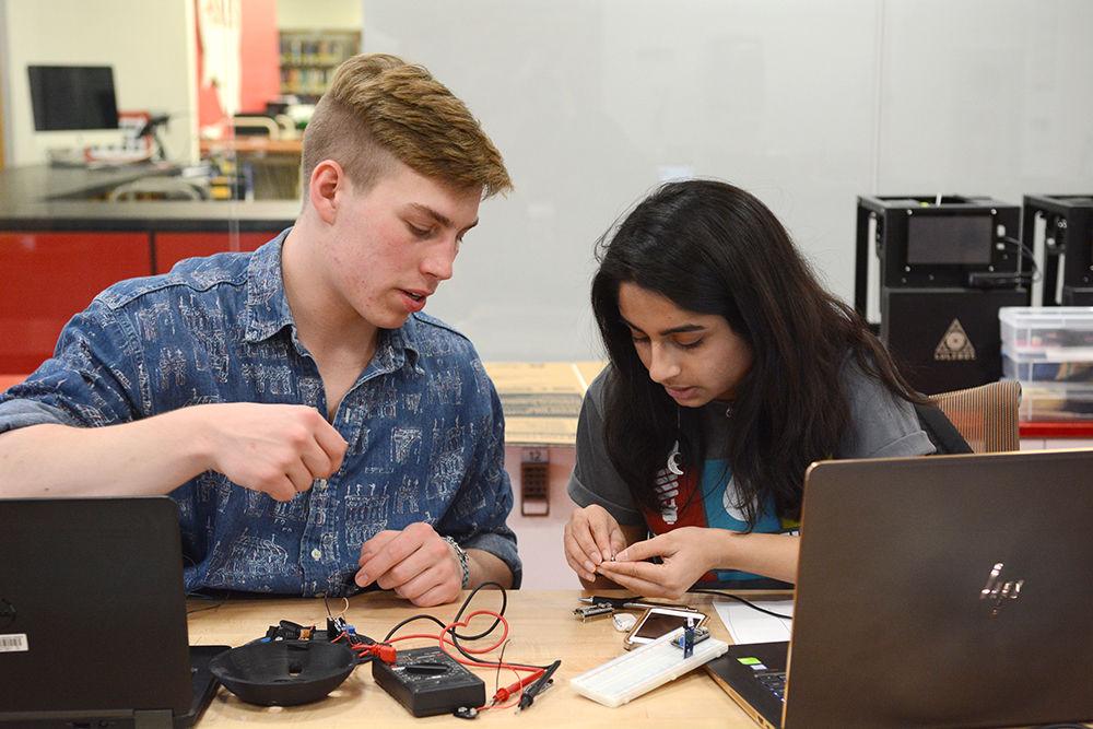 Christian Burke, a second-year student studying electrical engineering, and Mithila Khare, a second-year studying industrial engineering, work on a device that would allow drivers to reserve parking spots in advance in the Makerspace at D. H. Hill on Jan. 27, 2018 as part of Make-a-thon. Make-a-thon is an annual challenge at NC State in which student teams register to create sustainability solutions for a chance to win prizes. The challenge took place from Jan. 26 to Jan. 28.