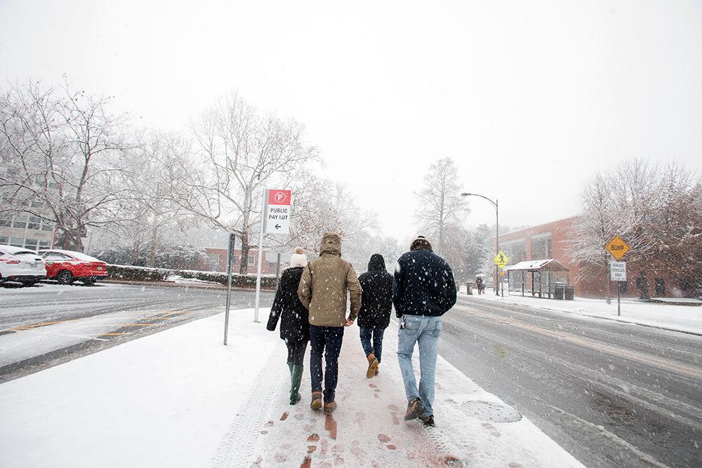 Four students walk together outside of Bragaw through the morning snow on Wednesday. Students did not start to see accumulation until approximately 11 a.m. Once started, snow cam down throughout the remainder of the day.
