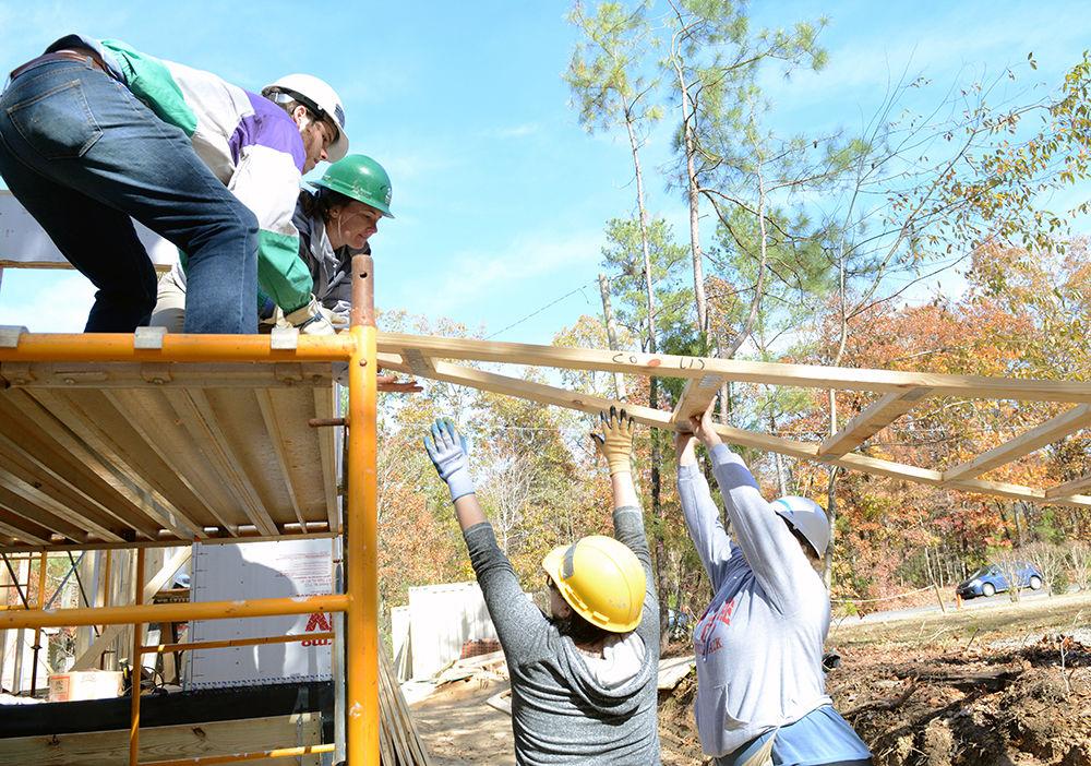 Cameron Hill, a fourth-year studying information science at UNC Chapel Hill, Molly Ashline, campus organizer with NCPIRG, and future homeowner Tami Ali lift up a truss for a roof for her home at a Habitat for Humanity build site in Holly Springs on Nov. 17, 2017. Members of The NC State chapter of the North Carolina Public Interest Research Group, including Ashline, helped fellow volunteers to build a home for Habitat for Humanity as part of Homelessness &amp; Hunger Awareness Week.&#160;
