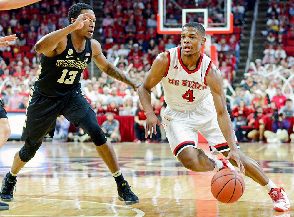 Freshman guard Dennis Smith Jr. dribbles the ball around a Wake Forest player toward the goal. Smith did well with his free throws during the game, scoring nine of 11. The NC State men&#8217;s basketball team lost to Wake Forest 88-93 at PNC Arena on Jan. 21, 2017.
