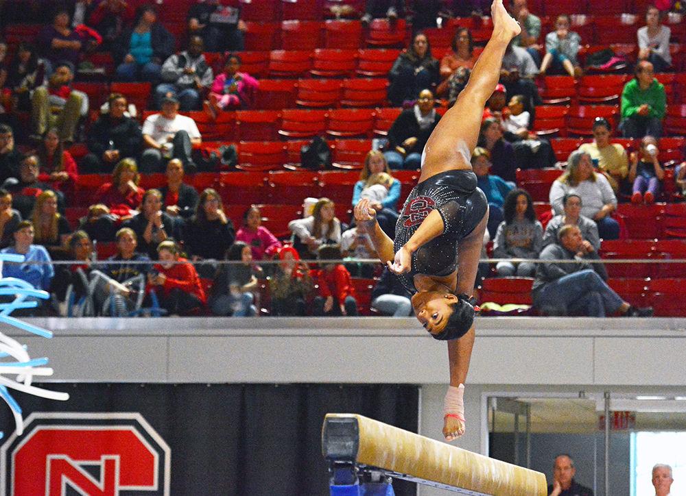 Junior gymnast Chelsea Knight flips into the air, showing her flexibility and great balance at the balance beam event at Reynolds Coliseum on March 18, 2017. Knight receives 9.775 in the vault event, 9.750 in the bars event, 9.775 in the beam event and 9.875 in the floor event which she won second place in. She also won third place with her all-around results of 39.175. The Wolfpack won third place with the score of 194.875 in the meet with George Washington University, University of New Hampshire, UNC-Chapel Hill, University of Pittsburgh and Towson University.