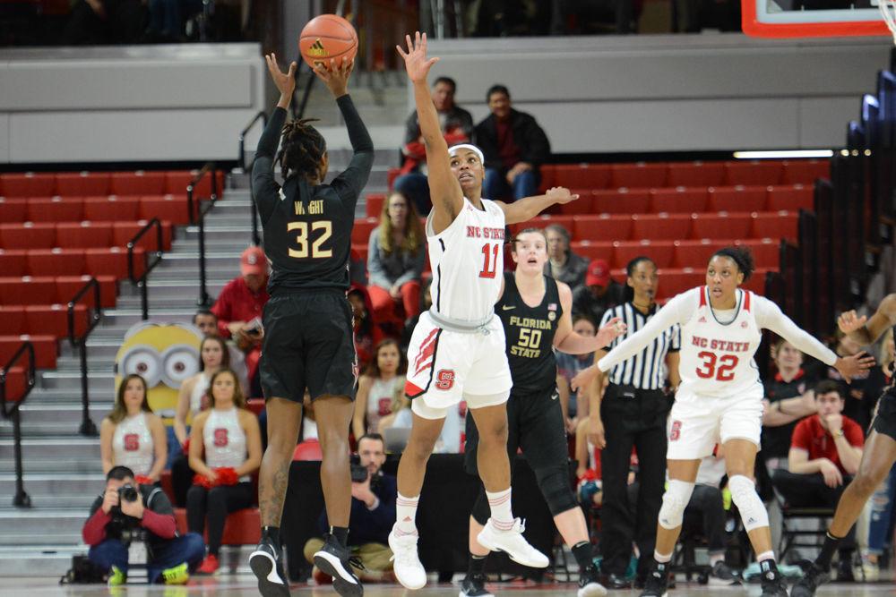 Red shirt Junior guard, Kiara Leslie attempts to block a three point shot from a Seminoles player. The Wolfpack won the game against the Seminoles by a score of 65-56 at Reynolds Coliseum on Thursday, Feb. 1. The Wolfpack are currently tied for fourth in the ACC division.