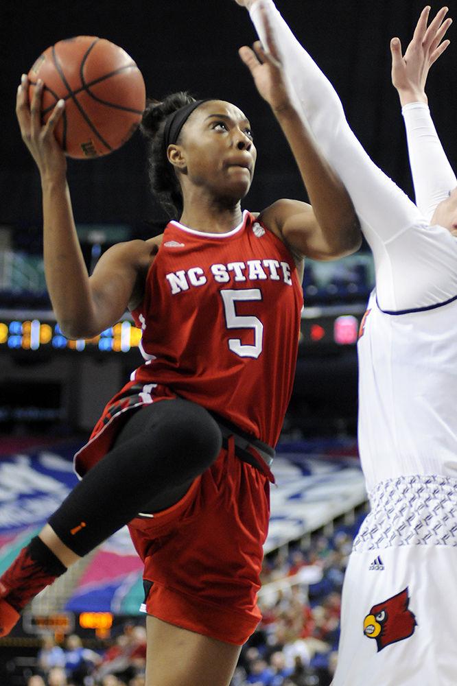 Senior forward Chelsea Nelson jumps up and fights against the defense for a shot at the ACC women's basketball semifinal against Louisville in Greensboro Coliseum on Saturday. The Wolfpack lost to the Cardinals with a final score of 64-59.