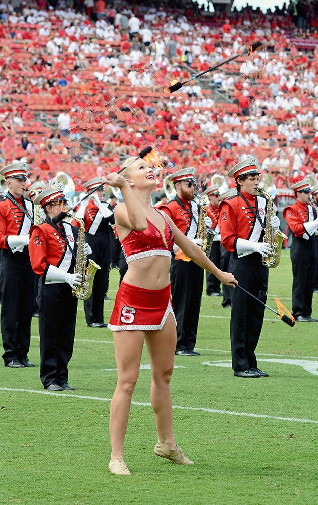 NC State majorette Valerie Stevens, a third-year studying mathematics education, twirls fiery batons during the halftime show on Sept. 16, 2017 at Carter-Finley Stadium. The Wolfpack Majorettes perform alongside the NC State marching band.