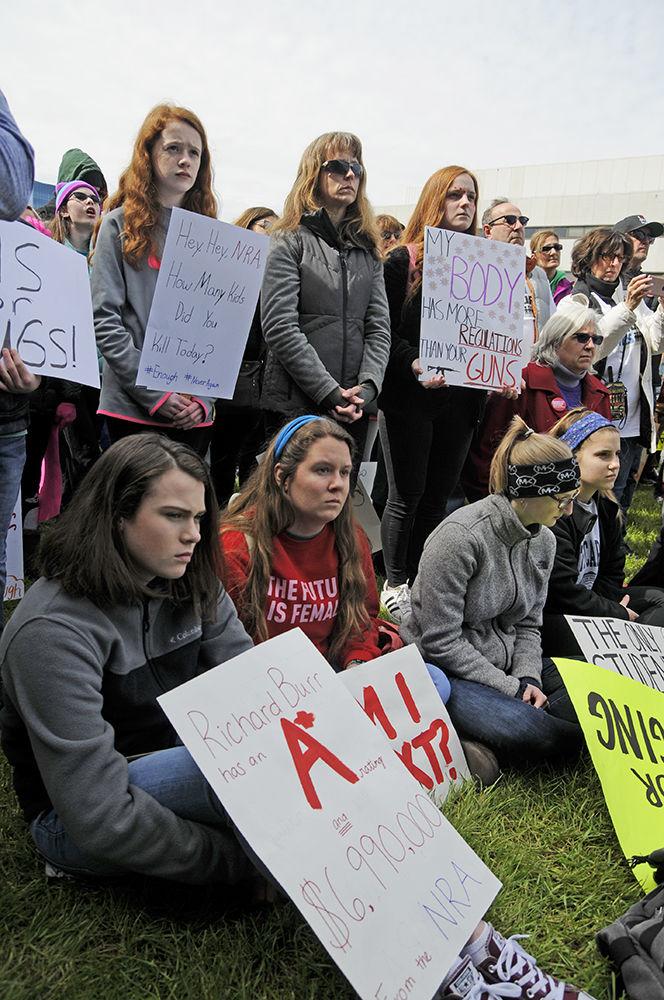 Protesters sit with their signs and listen to the speakers at the end of the "March for Our Lives" in downtown Raleigh on Saturday, March 24, 2018. The march advocated "common sense gun reform" in the wake of the school shooting in Parkland Florida as well as the numerous other shootings that have taken place in the United States.