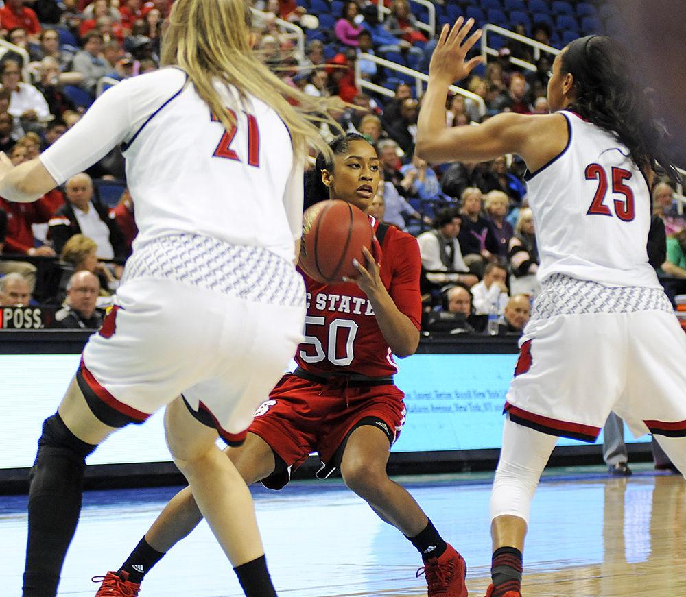 Redshirt junior point guard Armani Hawkins looks for an opening in the Louisville defense at the ACC women's basketball semifinal against Louisville in Greensboro Coliseum on Saturday. The Wolfpack lost to the Cardinals with a final score of 64-59.