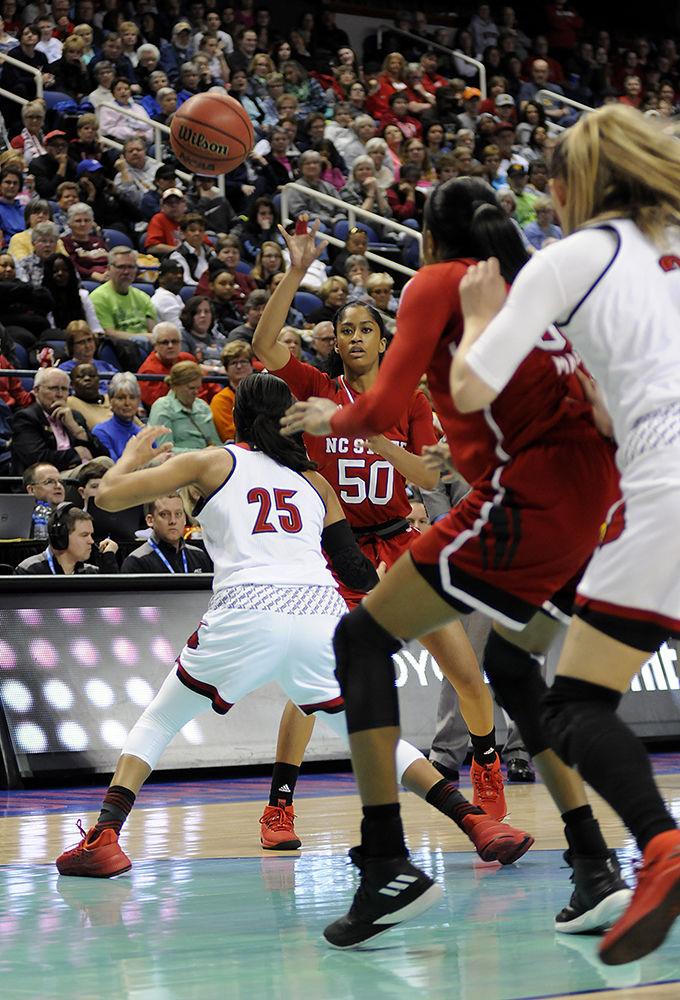 Redshirt junior point guard Armani Hawkins passes the ball to senior center Akela Maize at the ACC women's basketball semifinal against Louisville in Greensboro Coliseum on Saturday. The Wolfpack lost to the Cardinals with a final score of 64-59.
