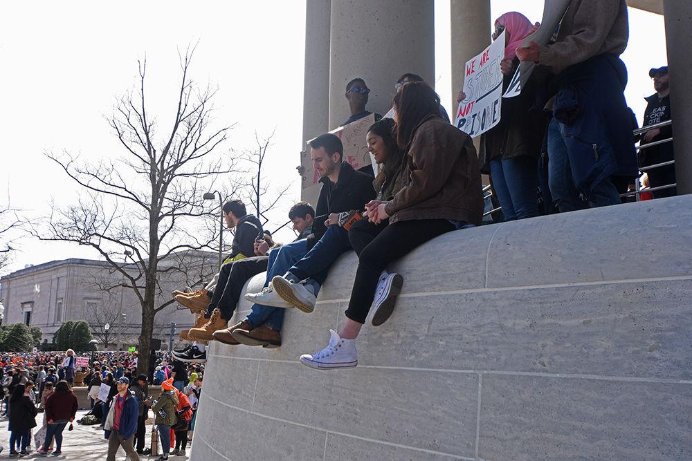 Participants sit on the ledge of the Canadian Embassy near Pennsylvania Avenue in Washington D.C. on Saturday, March 24, 2018. A multitude of people gathered here for a better view of the crowd and the stage where all the speakers and performers shared their feelings and thoughts to the world.