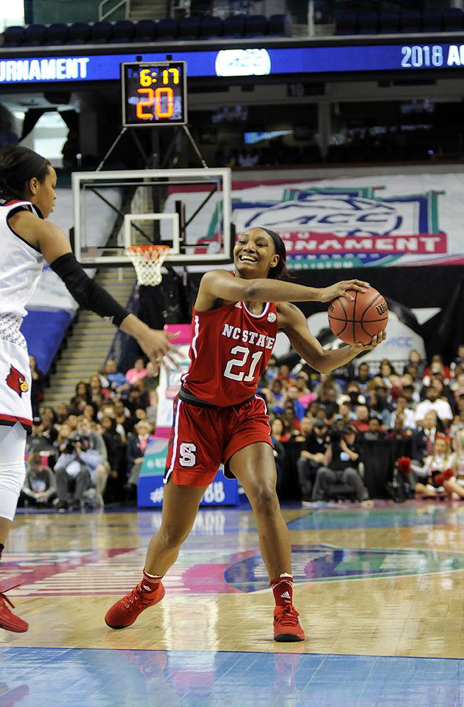 Junior forward DD Rogers looks for an opening to pass the ball to a teammate at the ACC women's basketball semifinal against Louisville in Greensboro Coliseum on Saturday. The Wolfpack lost to the Cardinals with a final score of 64-59.