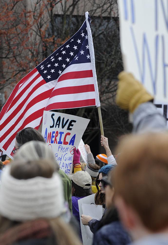 Protesters hold up their signs along with the American flag in a display of both protest and patriotism at the "March for Our Lives" in downtown Raleigh on Saturday, March. 24, 2017. The protest called for "common sense gun reform" in the wake of the multitude of mass shootings that have taken place in the United States school system.