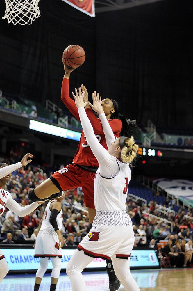 Senior center Akela Maize jumps up to score a field goal at the ACC women's basketball semifinal against Louisville in Greensboro Coliseum on Saturday. The Wolfpack lost to the Cardinals with a final score of 64-59.