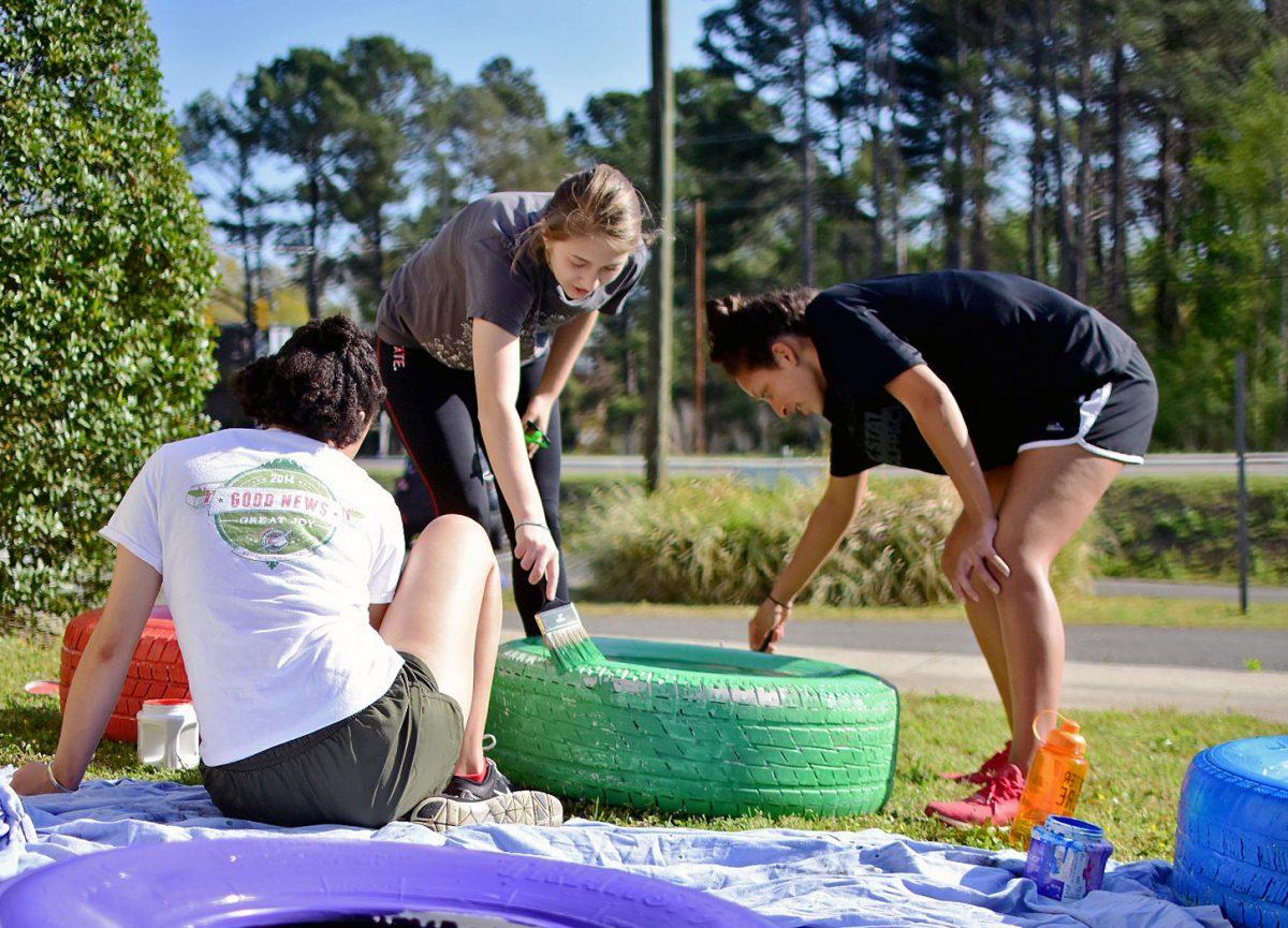 Kallyn Tall, a third-year studying social work, Payton Frye, a first-year studying psychology, and Karina Lacey, a fourth-year studying psychology, paint a tire at the Method Child Development Center as one of the 75 groups participating in Service Raleigh on Saturday. Tall, Frye and Lacey were part of a service group that went to Monte Cristo and stuck together.