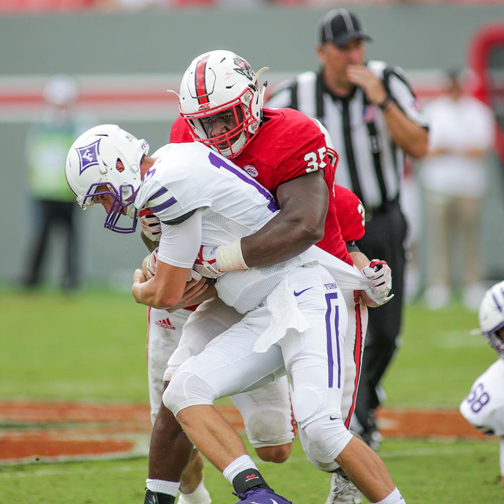 Senior defensive end Kentavius Street comes up with a big fourth-and-1 stop during the 49-16 win over Furman Saturday in Carter-Finley Stadium.