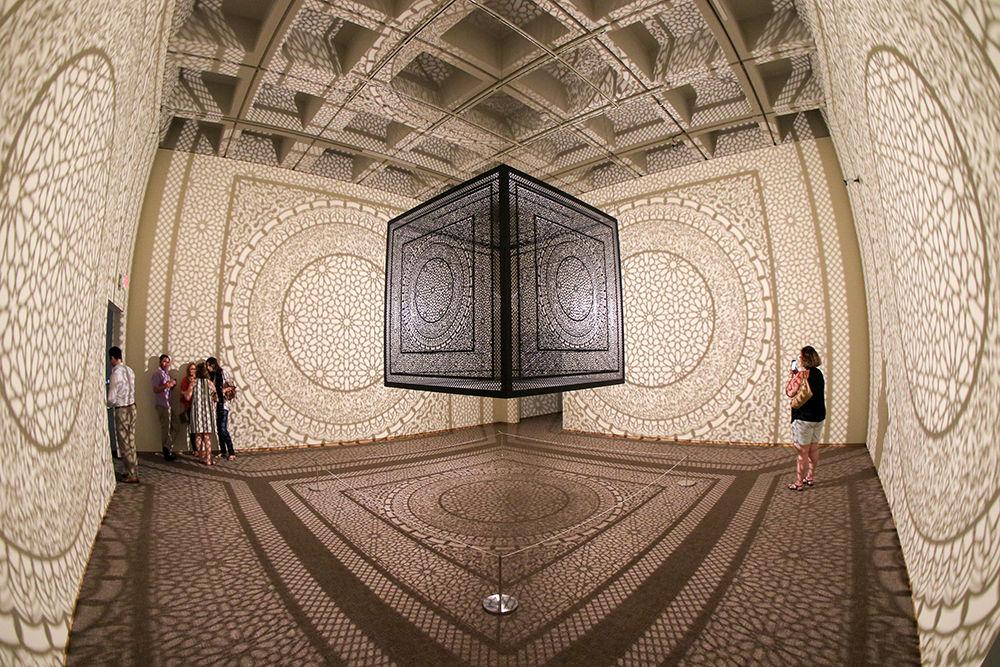 Anila Quayyum Agha's "Intersections" made of laser cut wood, lacquer paint and a light bulb lights the room as part of the "You are here" exhibit at the North Carolina Museum of Art. The exhibit features light, color and sound experiences and runs through July 22.