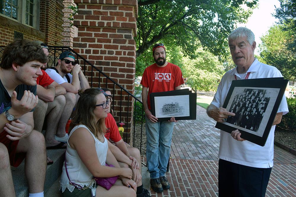 Dr. Tom Stafford Jr, former vice chancellor for student affairs, points to a picture of the first graduating class of NC State to a tour group on the steps of Holladay Hall during Packapalooza Saturday, August 19 2017. Stafford gives a tour, highlighting the history of the belltower as well as the history of the university, each year during Packapalooza.